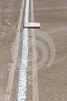 Close up of freshly chalked baseline, with base plate, dirt only, empty baseball field on a sunny day