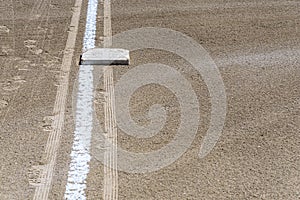 Close up of freshly chalked baseline, with base plate, dirt only, empty baseball field on a sunny day