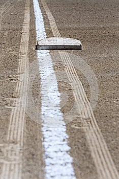 Close up of freshly chalked baseline, with base plate, dirt only, empty baseball field on a sunny day