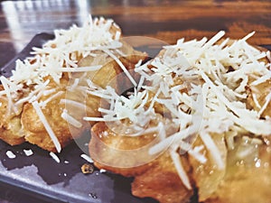 Close up of fried banana with cheese sprinkles