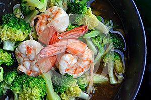 Close up of Fried Broccoli with Shrimps in Black Dish and Black Background