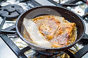 Close up fried fish fillet on pan photo