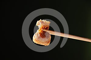 close-up of fried shrimp dumplings sandwiched with chopsticks
