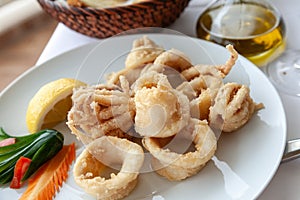 Close up of fried squid in batter served on a white plate in a mediterranean restaurant