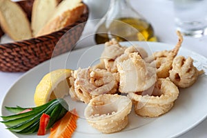 Close up of fried squid in batter served on a white plate in a mediterranean restaurant