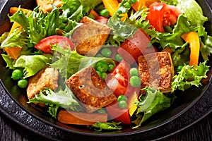 Tofu salad with greens and vegetables in bowl