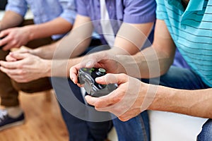 Close up of friends playing video games at home