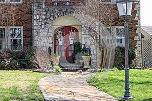 Close-up of front of house with beautiful flowers on double doors n early springtime with frisky squirrel running up the sidewalk photo