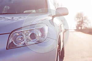 Close up front new silver SUV car. Detail of a modern car. Head light