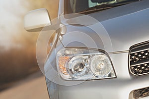 Close up front new silver SUV car. Detail of a modern car. Head light