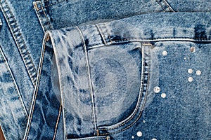 Close up on the front pocket stitching of a blue jeans