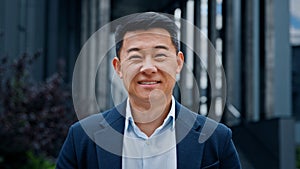 Close up front view in city outdoors Asian Korean man business boss leader company CEO smiling glad happy middle-aged