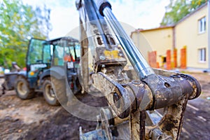 Close up front view on a mechanism or gear of cylinder actuator of digger bucket of excavator. The modern excavator