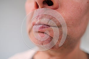 Close-up and front view of mouth of an old caucasian man in his sixties, with strong wrinkles, bright emotions on his face, male