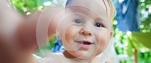 Close-up front view portrait of cute baby boy. Outdoor summer time