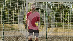 Close-up front view of soccer goalie training, catching ball outdoors