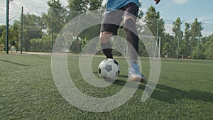 Close-up front view of soccer player legs in football boots with ball