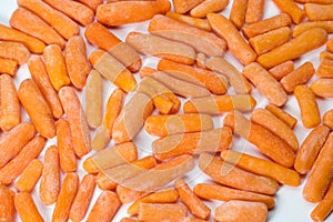 Close up of frozen baby carrots on white background
