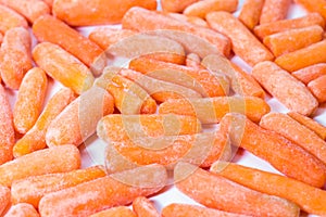 Close up of frozen baby carrots on white background