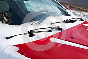 Close up of frozen windshield and red car wiper in winter