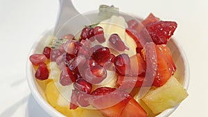 Close up frozen yogurt with mixed fruit in small bowl