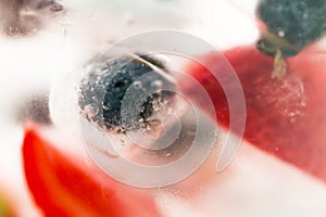 Close up of fruit water with ice cubes over glass