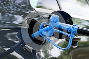 Close up of fuel cell car with connected hydrogen fueling nozzle. photo