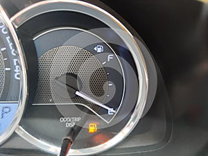 Close-up fuel gauge showing empty tank with yellow light glowing