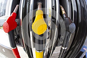 Close-up fuel nozzles on petrol and diesel fuel. Gas station pump. Man refueling gasoline with fuel in a car, holding a nozzle.