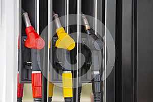 Close-up fuel nozzles on petrol and diesel fuel. Gas station pump. Man refueling gasoline with fuel in a car, holding a nozzle.