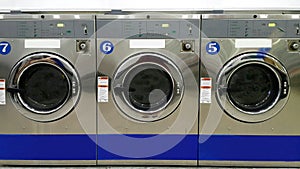 Close up full frame of industrial washing machines for public use in laundromat/ laundrette