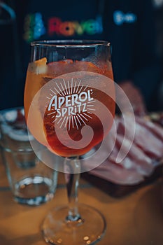 Close up of a full glass of Aperol Spritz cocktail,on an outdoor table of a restaurant