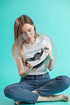 Close up full length portrait of sitting woman checking VR glasses