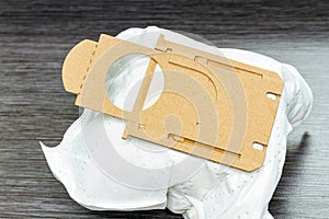 Close-up of full synthetic vacuum cleaner bag on brown wooden background