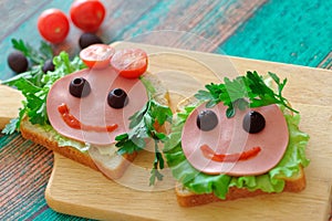 Close up of funny sandwiches the faces of a girl and a boy for a school lunch. Concept back to school