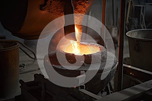 close-up of a furnace, with molten metal being poured into molds