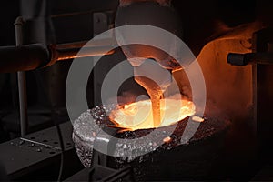 close-up of a furnace, with molten metal being poured into molds