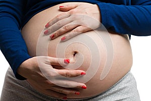 Close-up of future mother grabbing her tummy