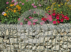 Close-up of a gabion support wall with wire mesh reinforcement and pebbles