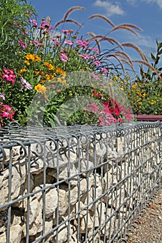 Close-up of a gabion support wall with wire mesh reinforcement and pebbles