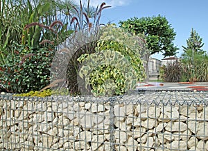 Close-up of a gabion support wall with wire mesh reinforcement and pebbles