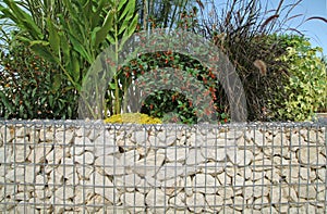 Close-up of a gabion support wall with wire mesh reinforcement and pebbles