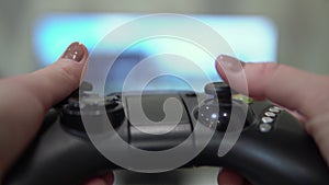 Close up of game joystick in female hands. Girl playing computer games with a joystick