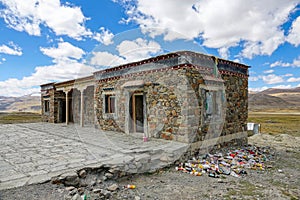 CLOSE UP: Garbage starts piling up next to an abandoned stone house in Tibet.