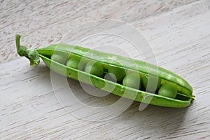 Close up of garden peas in a pod (Pisum sativum)