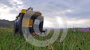 Close up of gas diesel mobile portable electricity generator work on grass. Gasoline fuel powered portable generator