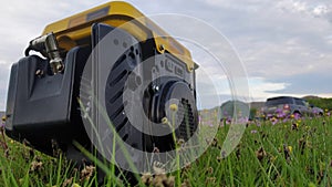 Close up of gas diesel mobile portable electricity generator work on grass. Gasoline fuel powered portable generator