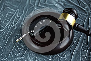 Close-up Of Gavel And Car Key On Sounding Block Against