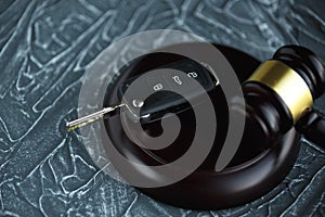 Close-up Of Gavel And Car Key On Sounding Block Against