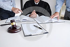 Close up of gavel, Male lawyer and older judge Consult with client on the case and working with Law books, report the case on tab